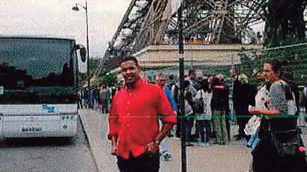 Omar Hychami standing beside the Eiffel Tower in Paris