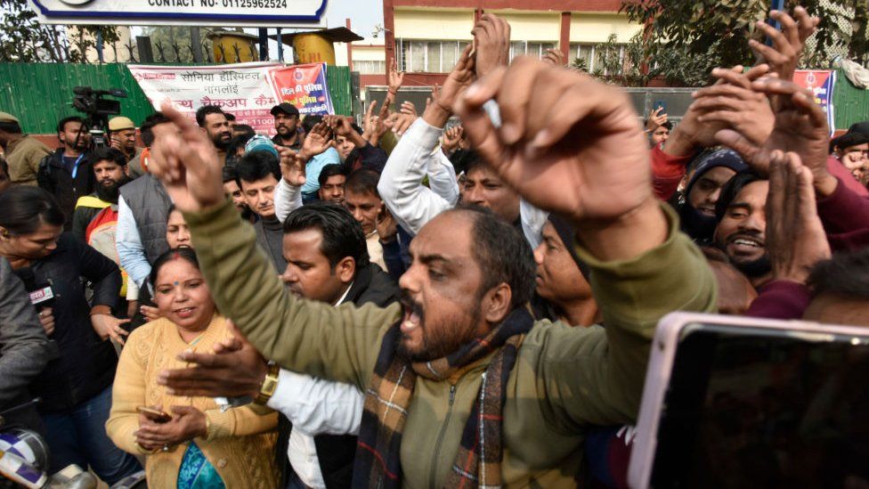 Сотни людей собрались у полицейского участка Султанпури, требуя строгих мер против пятерых мужчин, находившихся в машине, которая врезалась в скутер женщины, 2 января 2023 года в Нью-Дели, Индия.