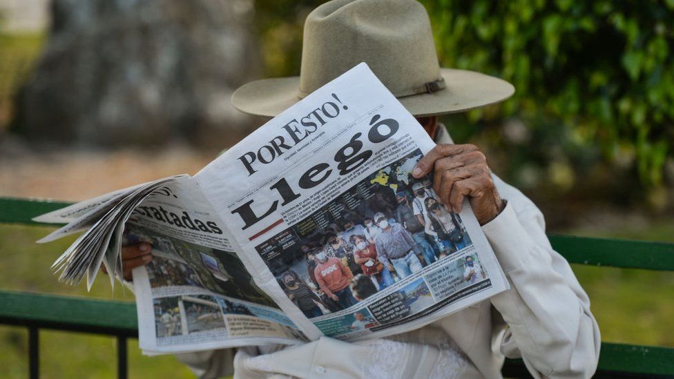 A man reads 'Por Esto!' (English: 'That's Why!'), a daily Mexican newspaper that covers the Mexican states of Yucatán, Campeche, and Quintana Roo, December 2021