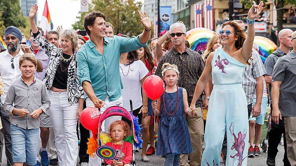 Justin Trudeau waves while at a pride parade with his wife and children