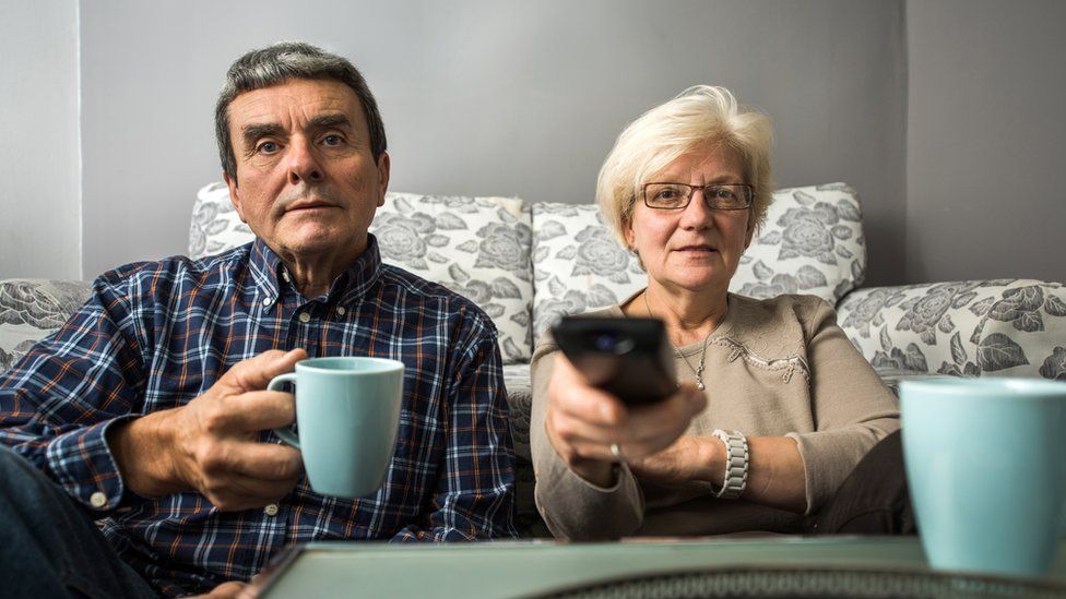 Couple watching TV at their home
