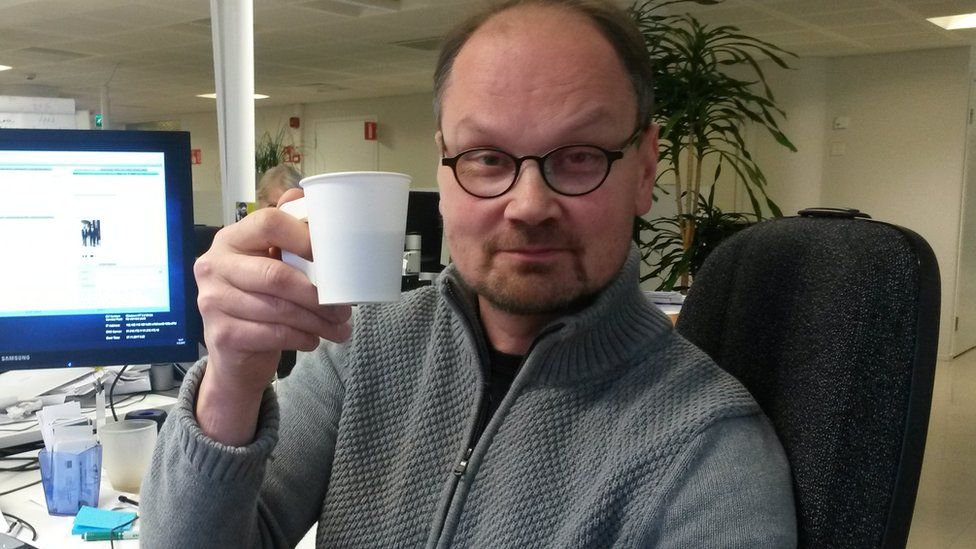 Niilo Simojoki drinking a coffee in his office in Helsinki, Finland