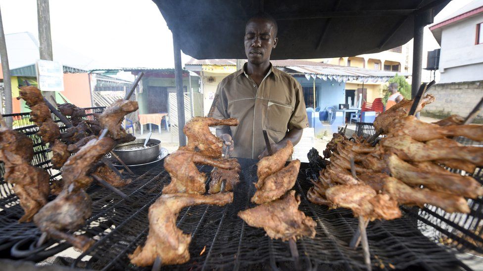 A man cooking chickens in Nigeria