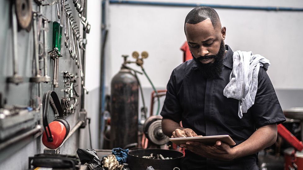 Mechanic on tablet in workshop