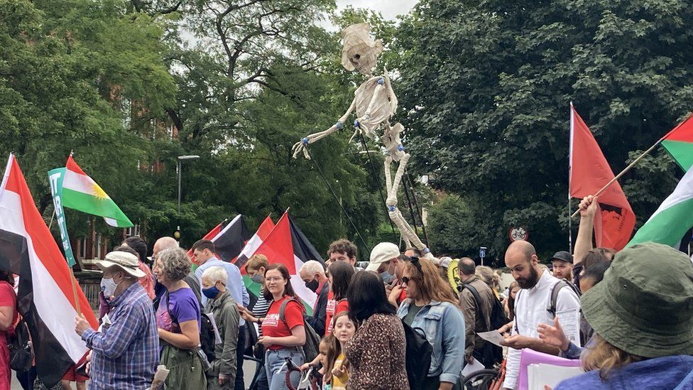 skeleton replica held aloft during protest march