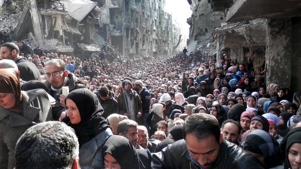 2014 file photo of Palestinians in Yarmouk queuing for food