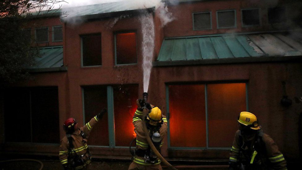 Firefighters try to extinguish a house fire near Calistoga, California