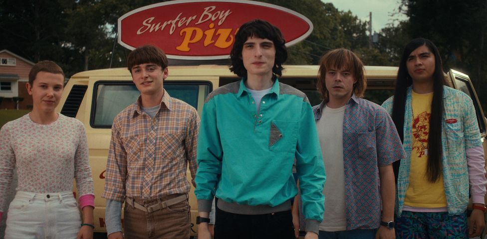 (L to R) Millie Bobby Brown as Eleven, Noah Schnapp as Will Byers, Finn Wolfhard as Mike Wheeler, Charlie Heaton as Jonathan Byers, and Eduardo Franco as Argyle in STRANGER THINGS