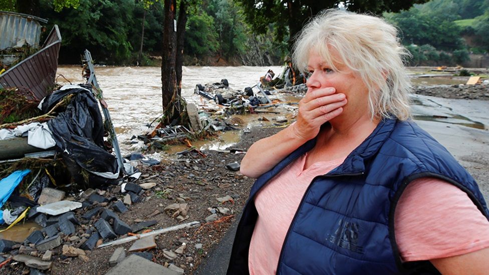 Женщина смотрит на обломки, принесенные наводнением у реки Ар
