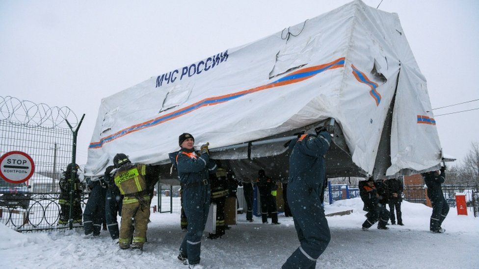 Specialists of Russian Emergencies Ministry carry a tent during a rescue operation following a fire in the Listvyazhnaya coal mine in the Kemerovo region, Russia, November 25, 2021