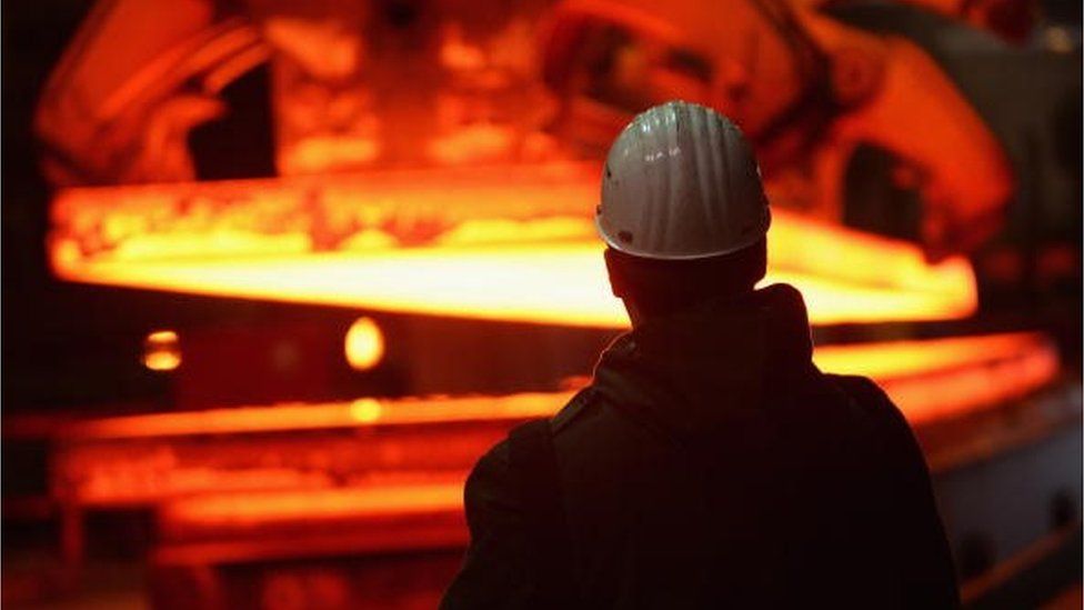A worker watching steel melt