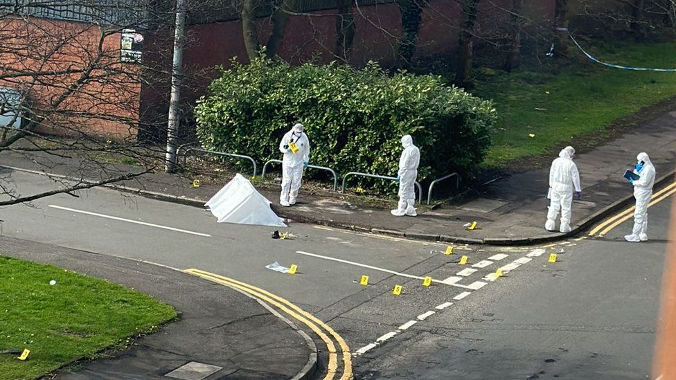 Forensic officers gather evidence at the scene