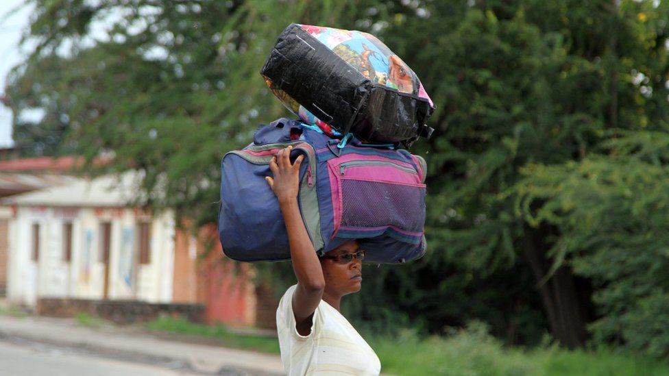 A Burundian woman carries her belongings on her head in Bujumbura, Burundi, Saturday, Nov. 7, 2015.