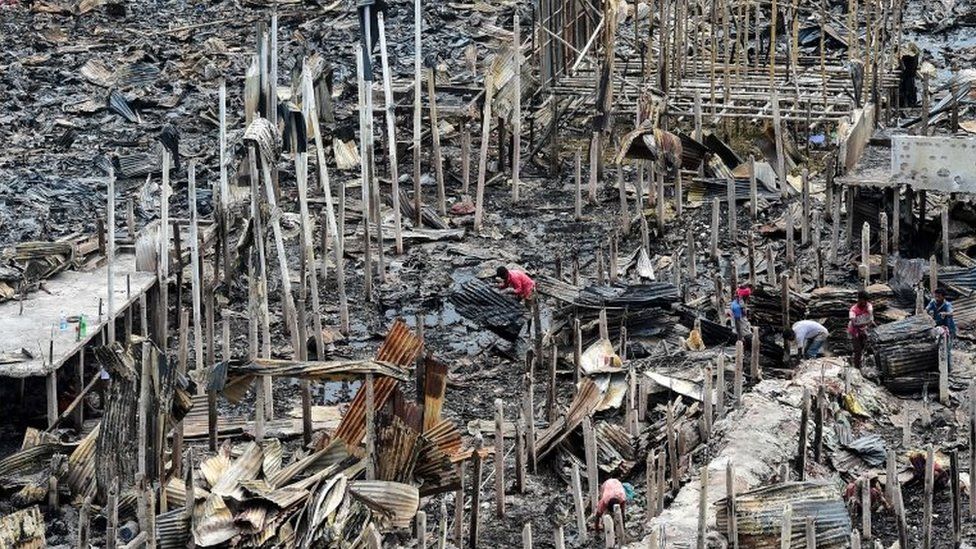 resident gathers charred debris in a slum in Dhaka on 18 August 2019, after a fire broke out late on August 17 at Mirpur neighbourhood