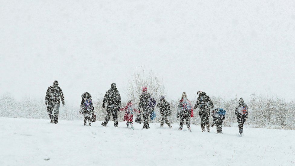 People walking through snow