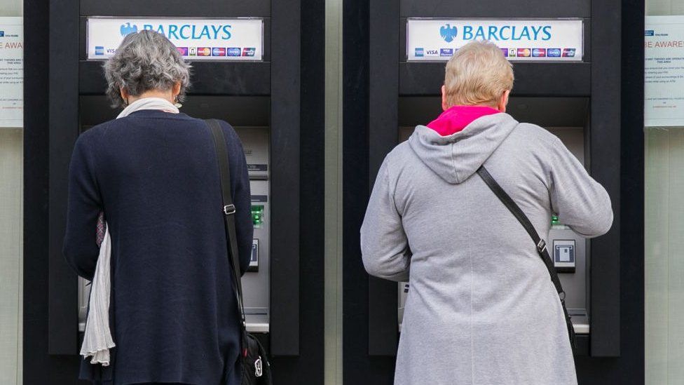 Two women using an ATM