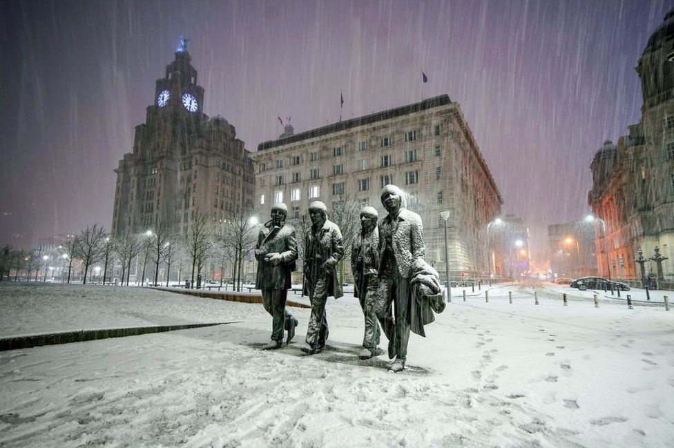 Snow falls on the Beatles Statue at Pier Head, Liverpool