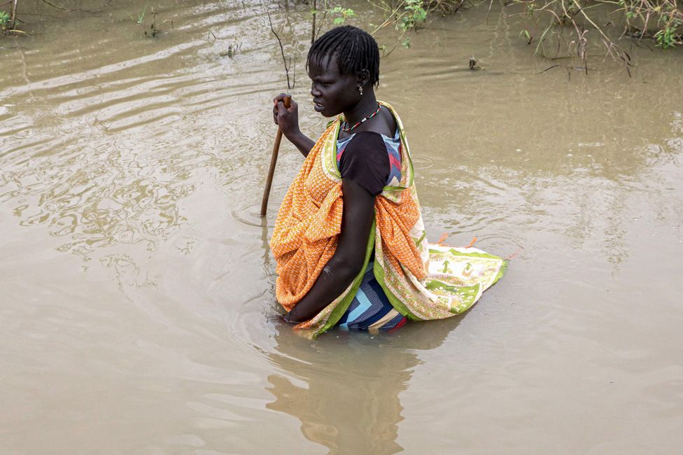 A South Sudanese woman walks in a flooded area that has been isolated for about a month and a half due to the heavy rain in Pibor Town, Boma state,