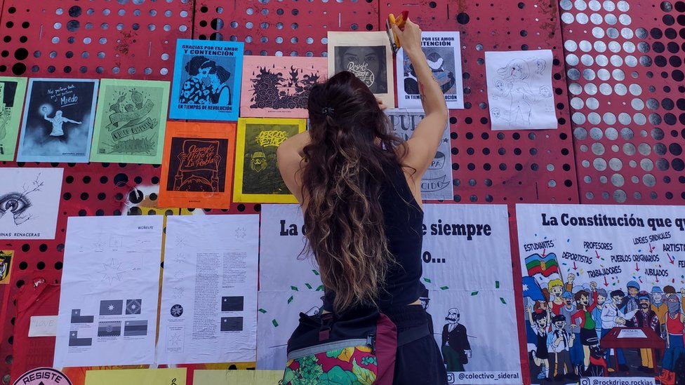 A woman attaches posters