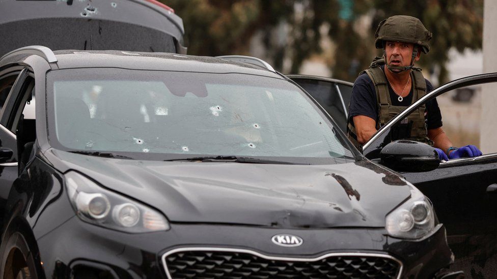 Сотрудник израильских сил безопасности осматривает автомобиль на месте предполагаемого тарана автомобиля недалеко от оккупированного Западного берега (29 ноября 2022 г.)