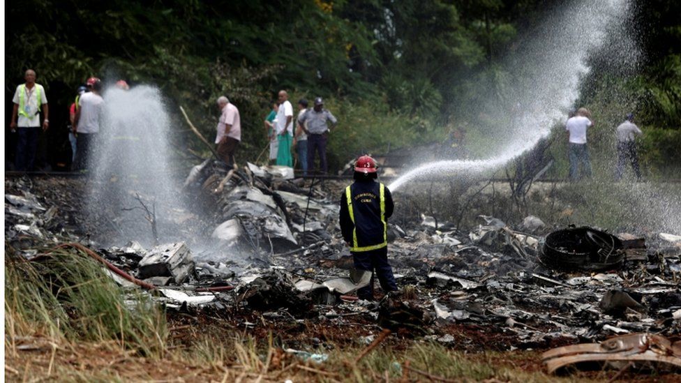 Пожарный и обломки Боинга-737, разбившегося вскоре после взлета из международного аэропорта Хосе Марти в Гаване, Куба, 18 мая 2018 г.