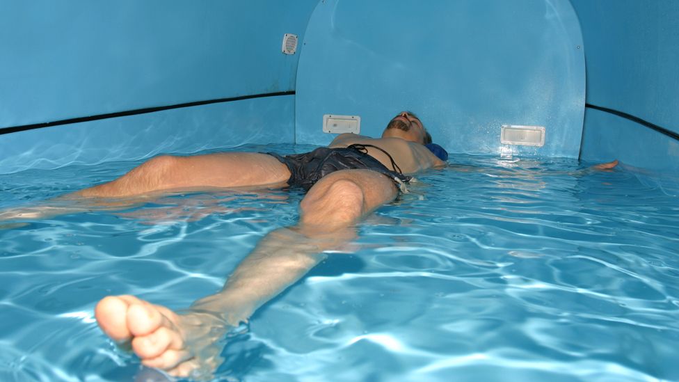 Man lies back in flotation tank