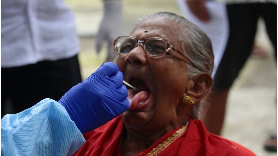 An elderly woman giving swab