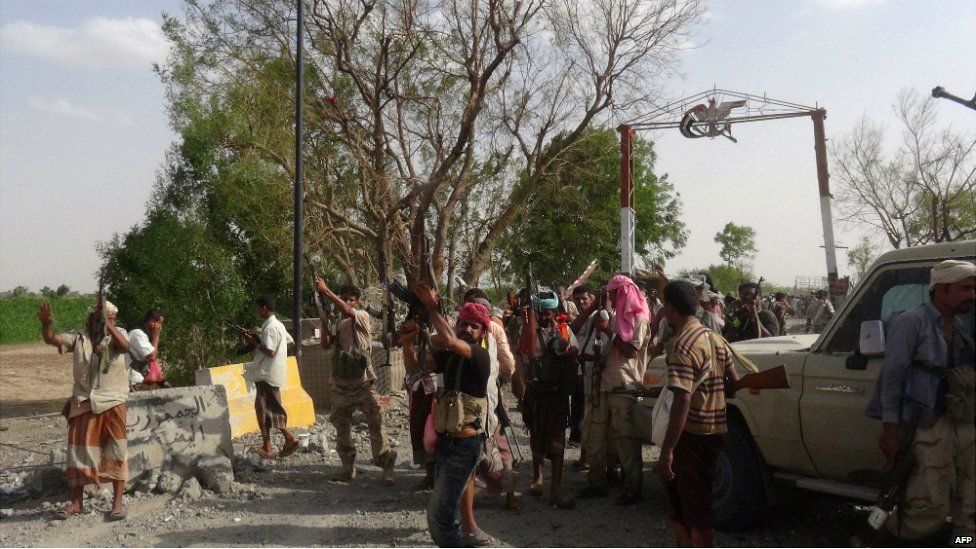 Yemeni pro-government forces backed by a Saudi-led coalition celebrate outside one of the entrances of the key Al-Anad military base in the southern Lahj governorate, some 50km north of the Red Sea port of Aden - 3 August 2015