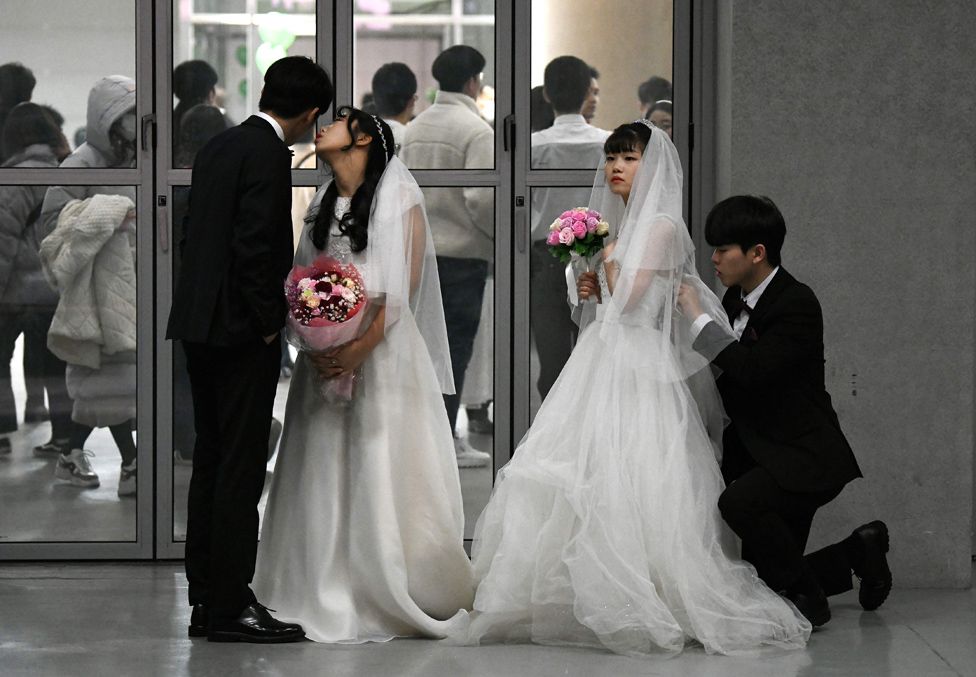 Couples prepare for their performances at a mass wedding ceremony organised by the Unification Church in South Korea.