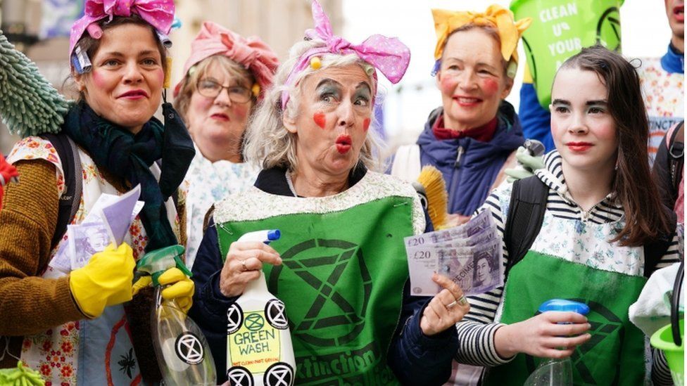 Climate activists take part in a Green Rebellion greenwashing protest on Buchanan Street during COP26