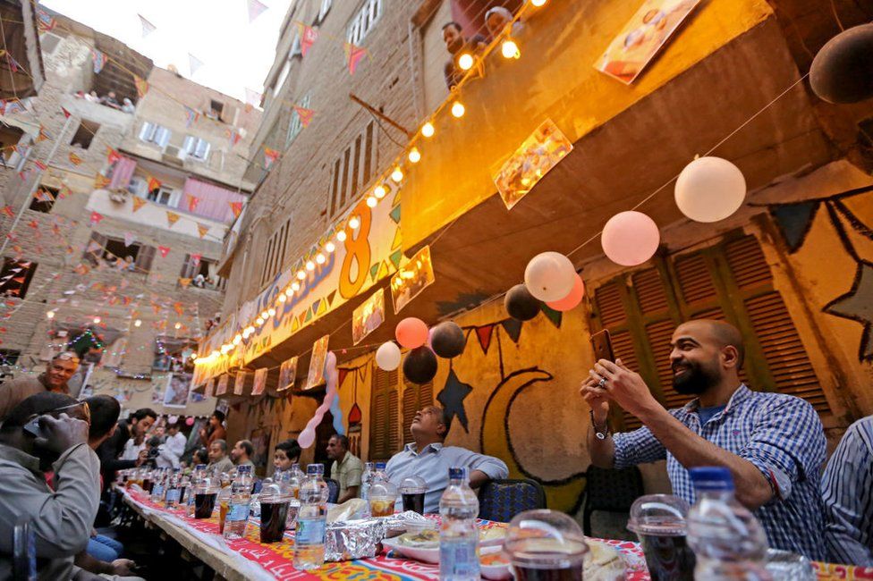 Egyptians eat during a mass Iftar gathering at Ezbet Hamada in al-Matariyyah district during the holy month of Ramadan.