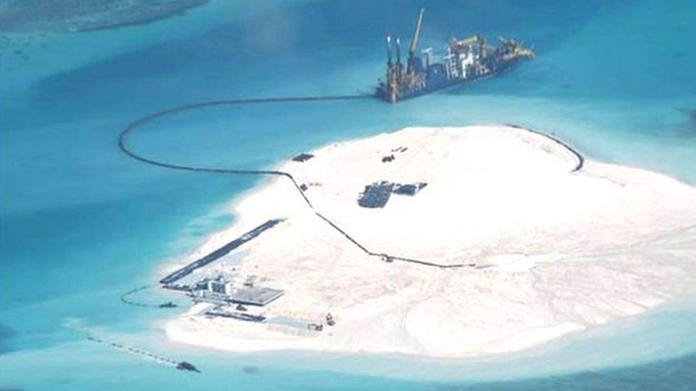 In this 25 Feb 2014 file photo taken by surveillance planes and released 15 May by the Philippine Department of Foreign Affairs, a Chinese vessel, top centre, is used to expand structures and land on the Johnson Reef, called Mabini by the Philippines and Chigua by China, at the Spratly Islands in the South China Sea, Philippines.