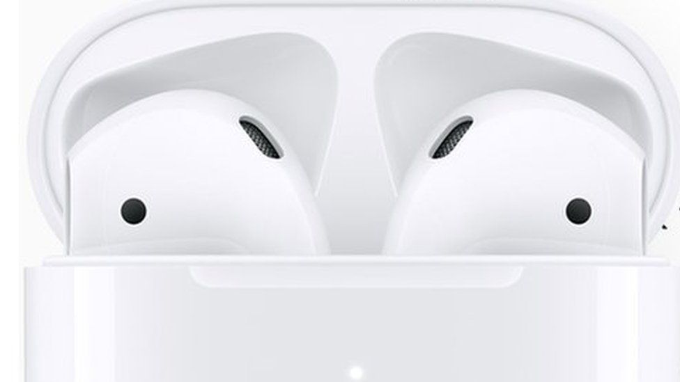 The new AirPods with Siri support shown in front of an iPhone screen
