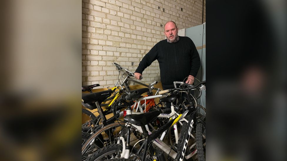 Mark Powell standing next to bikes