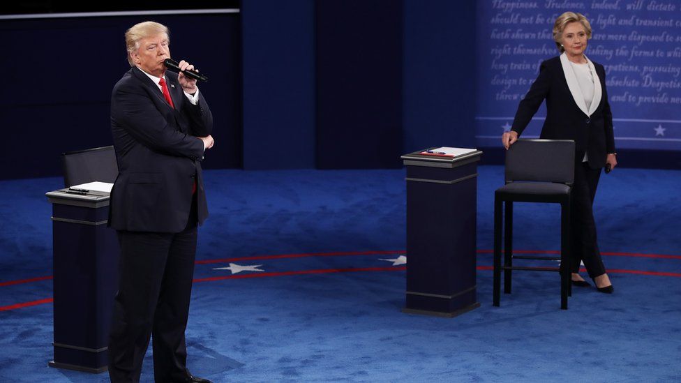 Republican U.S. presidential nominee Donald Trump looks on as Democratic U.S. presidential nominee Hillary Clinton speaks during their presidential town hall debate at Washington University in St. Louis, Missouri, U.S., October 9, 2016.