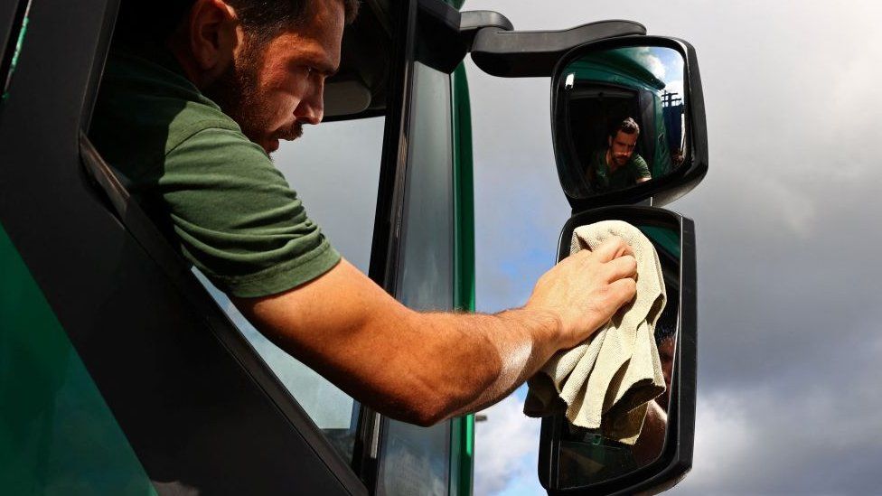 35-летний британский водитель Стивен Эбботт сидит в своей кабине во время перерыва в вождении на стоянке для грузовиков в Эшфорде.