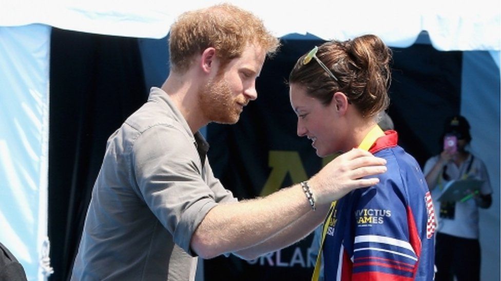 Prince Harry presents Elizabeth Marks with her medal