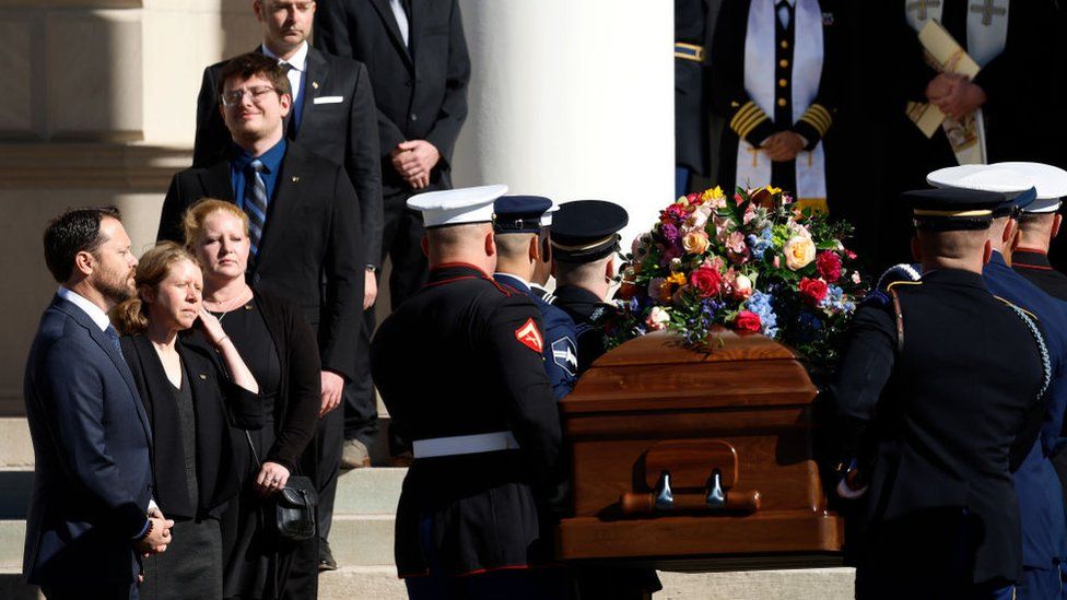 Rosalynn Carter's grandchildren watch on as her coffin is carried into the service
