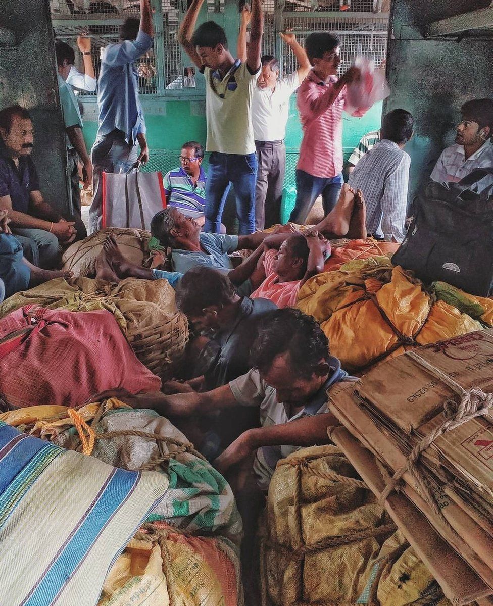 Passengers crowd the inside of a luggage compartment in a local train in Kolkata.