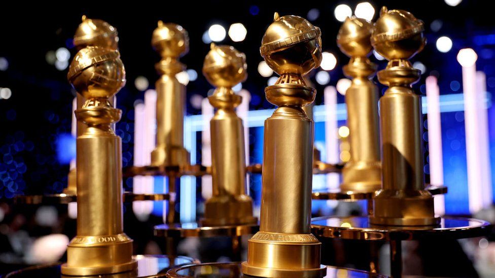 Image shows a row of Golden Globe awards