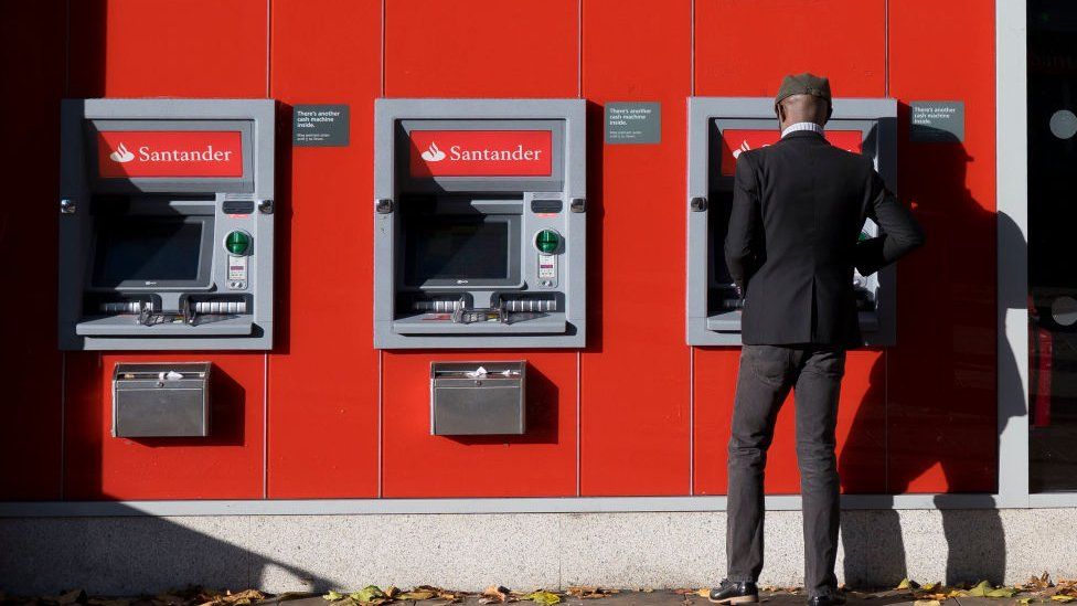 Man stood at Santander cash machines in Cardiff, Wales