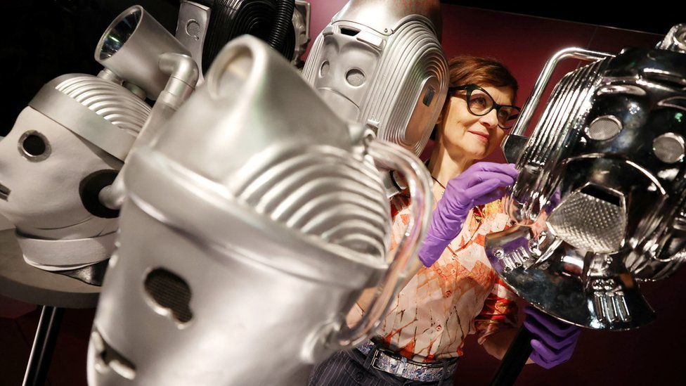 Sculpture conservator Marisa Prandelli adjusts a display of heads of "Cybermen" in the monster vault at the Doctor Who exhibition