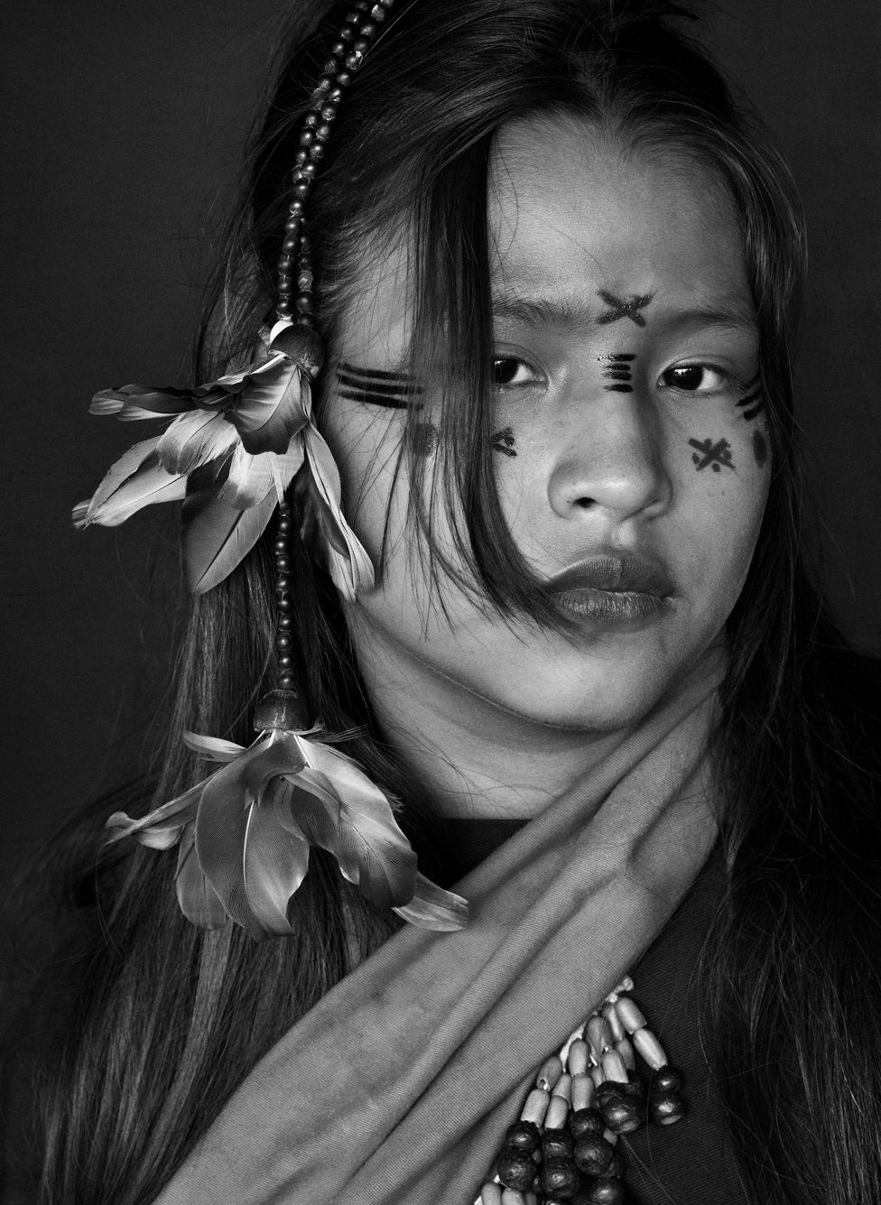 Black and white portrait of a girl with painted designs on her face