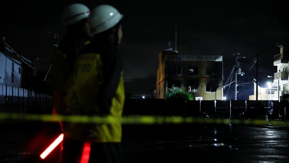 Guards stand in front of the Kyoto Animation building