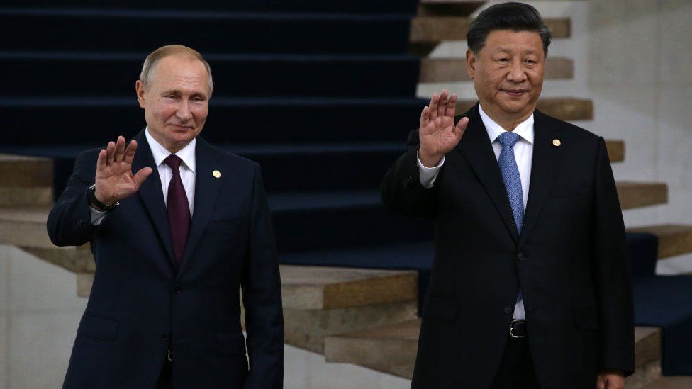 Russian President Vladimir Putin (L) and Chinese President Xi Jinping (R) wave during a welcoming ceremony on November 14, 2019 in Brasilia, Brazil. Leaders of Russia, China, Brazil, India and South Africa have gathered in Brasila for the BRICS Leaders Summit