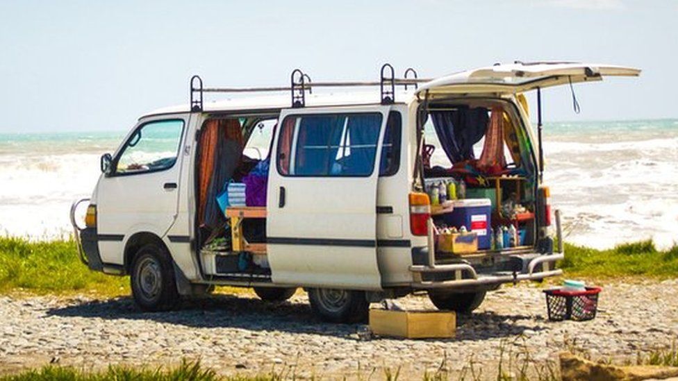A campervan parked in a bay area by the beach