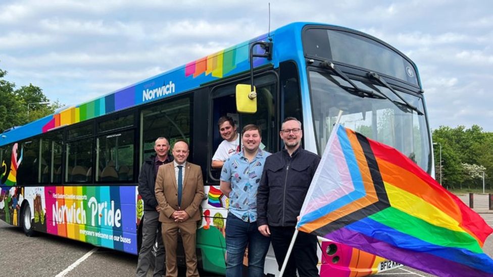 Bus decorated in pride flag colours