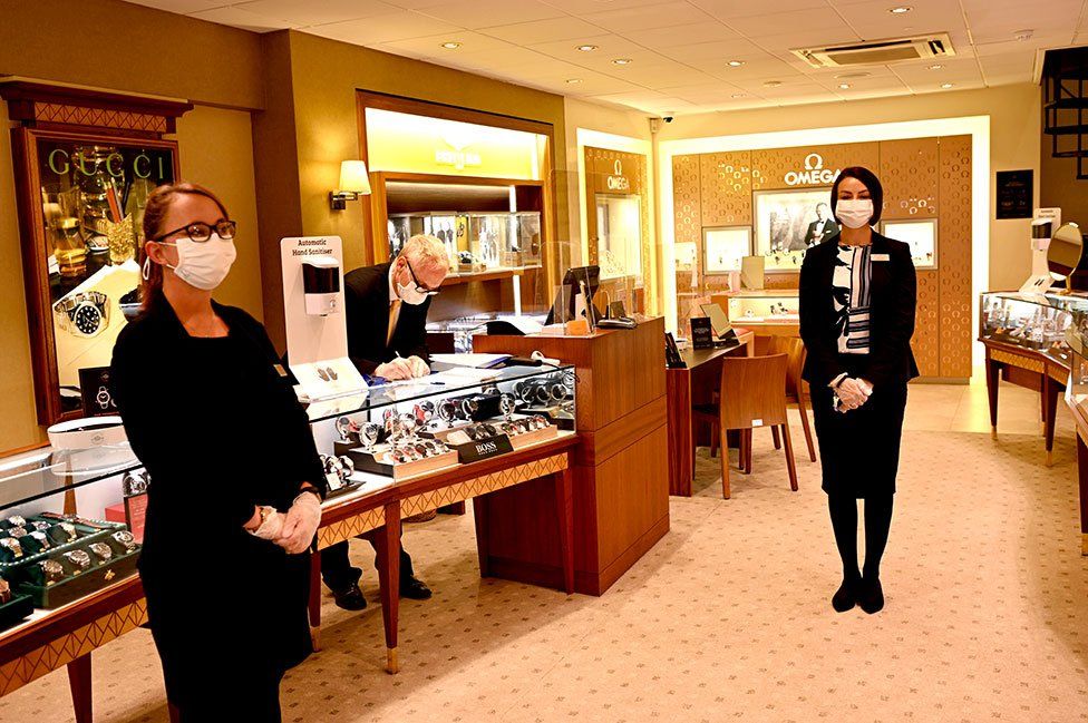Shop assistants wear masks in a jewellery store