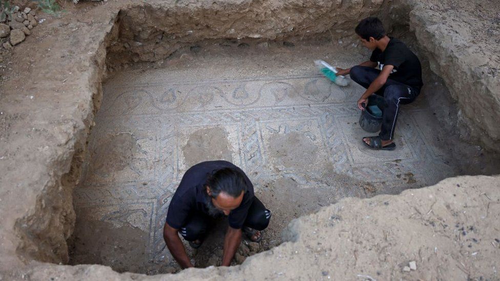 Salman al-Nabahib and his son clean another part of the mosaic in Gaza
