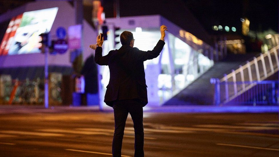 A man holds his hands up as police officers check him on a street after exchanges of gunfire in Vienna, Austria November 2, 2020